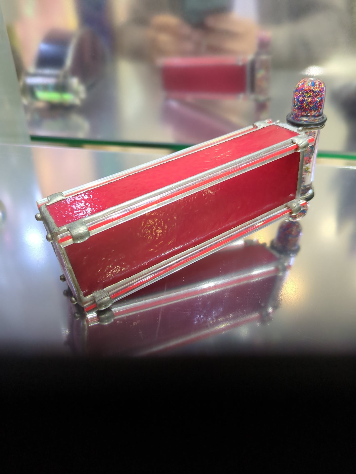 Decorative red kaleidoscope with silver accents and colorful top