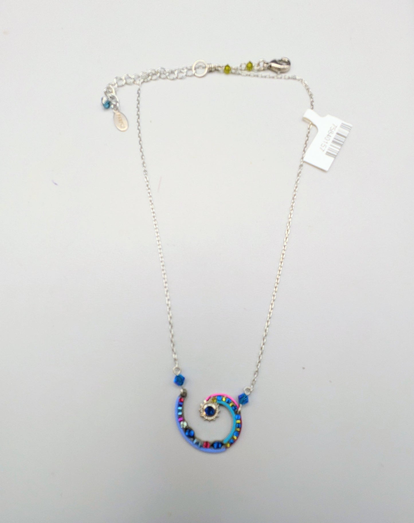 A silver chain necklace with a spiral pendant decorated with blue, pink, and purple rhinestones, displayed on a white jewelry box.