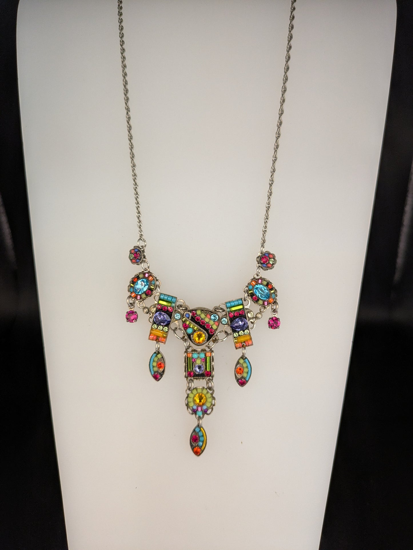 Multicolored beaded necklace on a white mannequin bust.