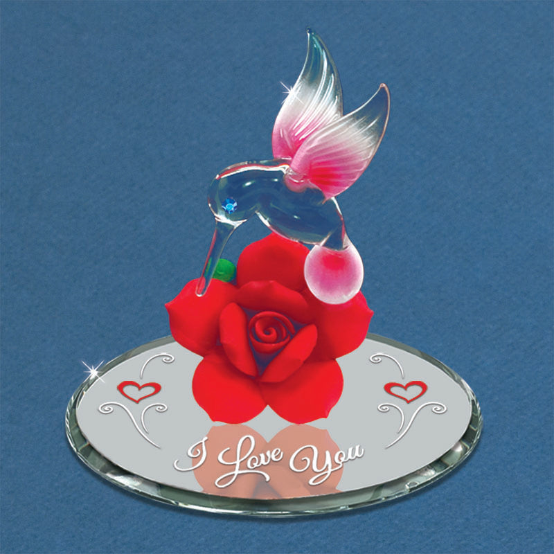 Handcrafted figurine of a hummingbird perched on a red rose with 'I Love You' embossed on it, placed on a circular mirror.
