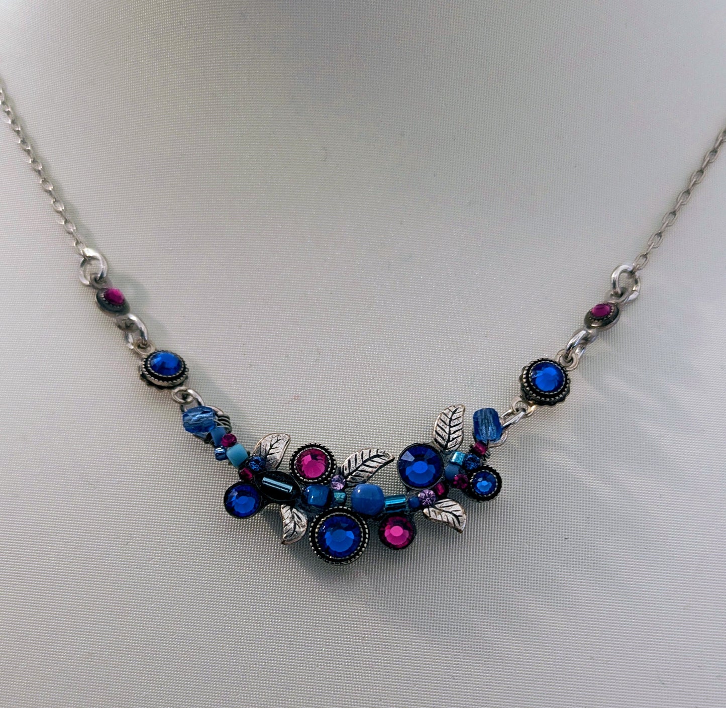 Necklace with blue and pink gemstones on a light gray background