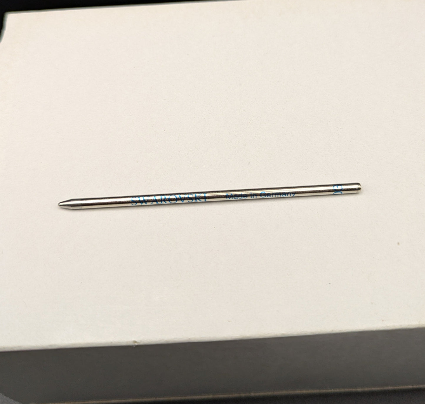 Pen refill on a white box with a black background