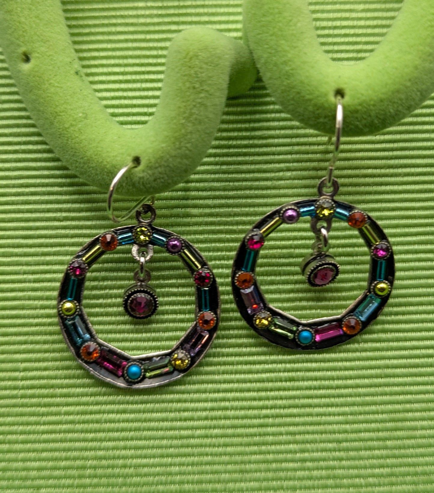 Colorful hoop earrings on a green stand