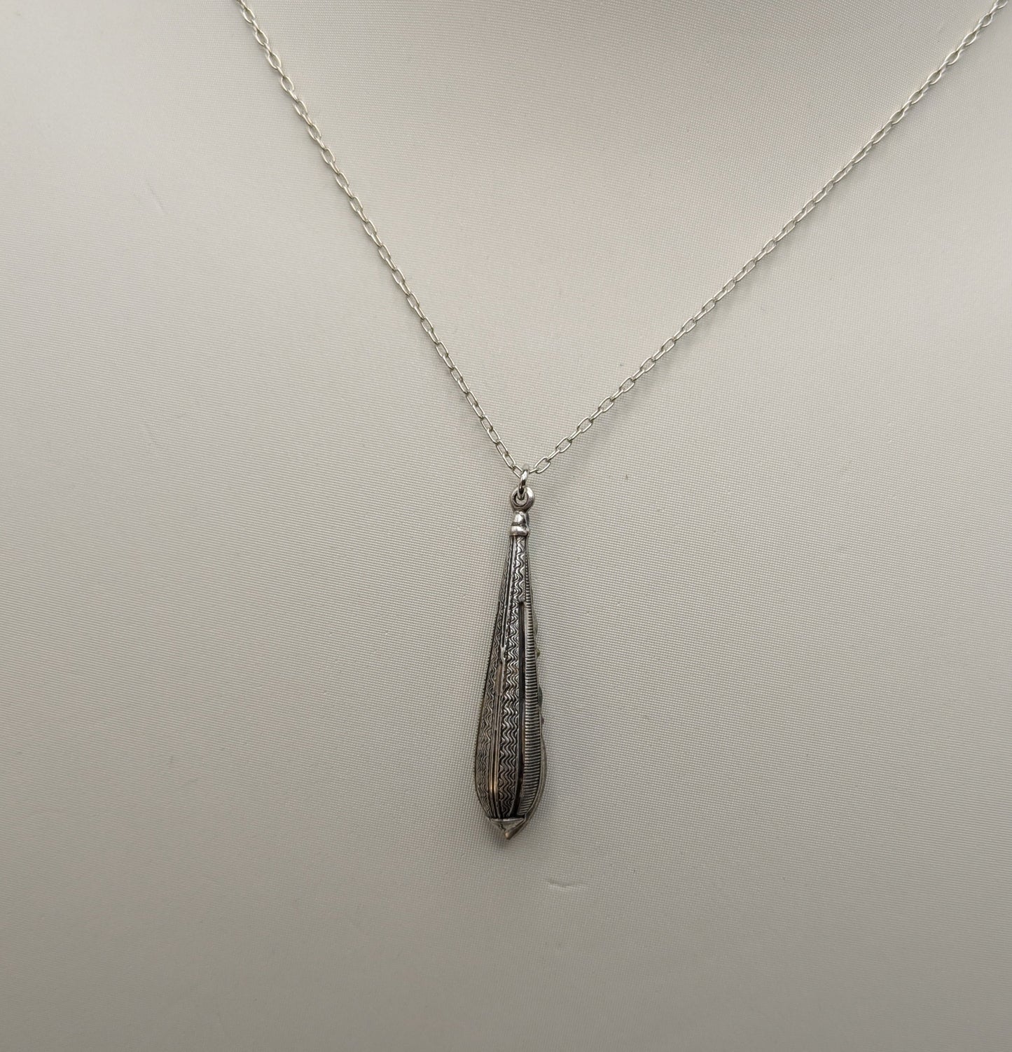 Necklace with a teardrop-shaped pendant on a mannequin bust.