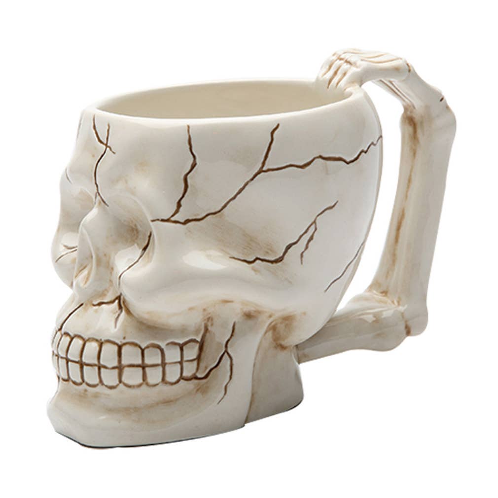 Skull-shaped mug with a skeleton hand on a white background