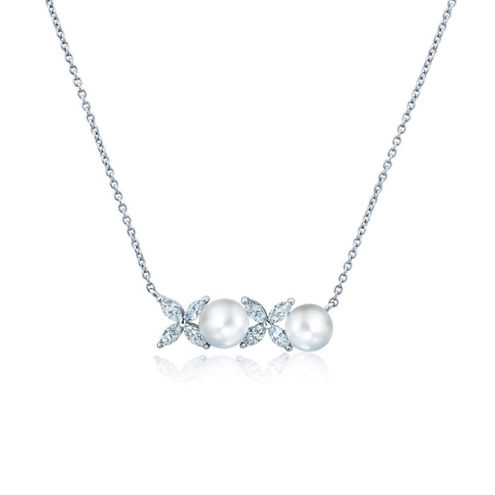 A white pearl necklace with a silver chain and a series of cubic zirconia embellishments.