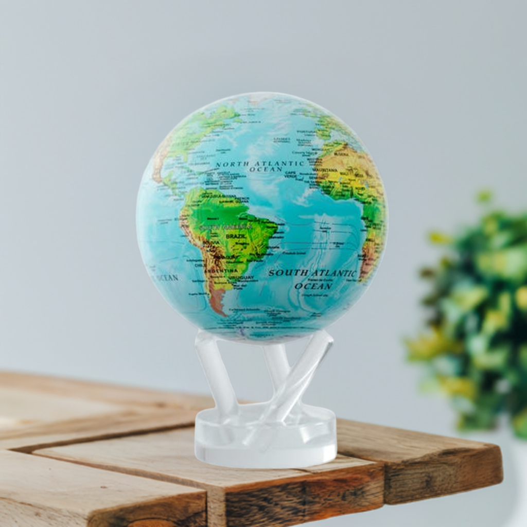A blue and green globe with lines showing ocean currents, mounted on a clear stand, with visible landmasses and a label for the South Atlantic Ocean in white background.