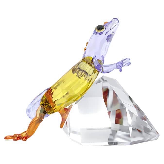 A multicolored crystal figurine of a gecko view from side on white background.