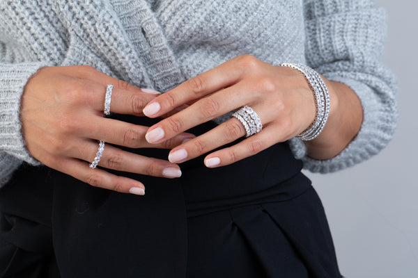 A model is wearing brilliant round cut eternity band.