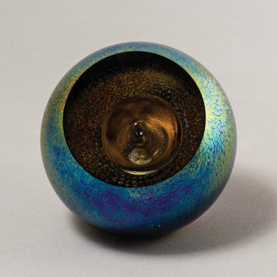 A Glass Eye Studio celestial series paperweight with blue and gold colors, approximately 3 inches in diameter.