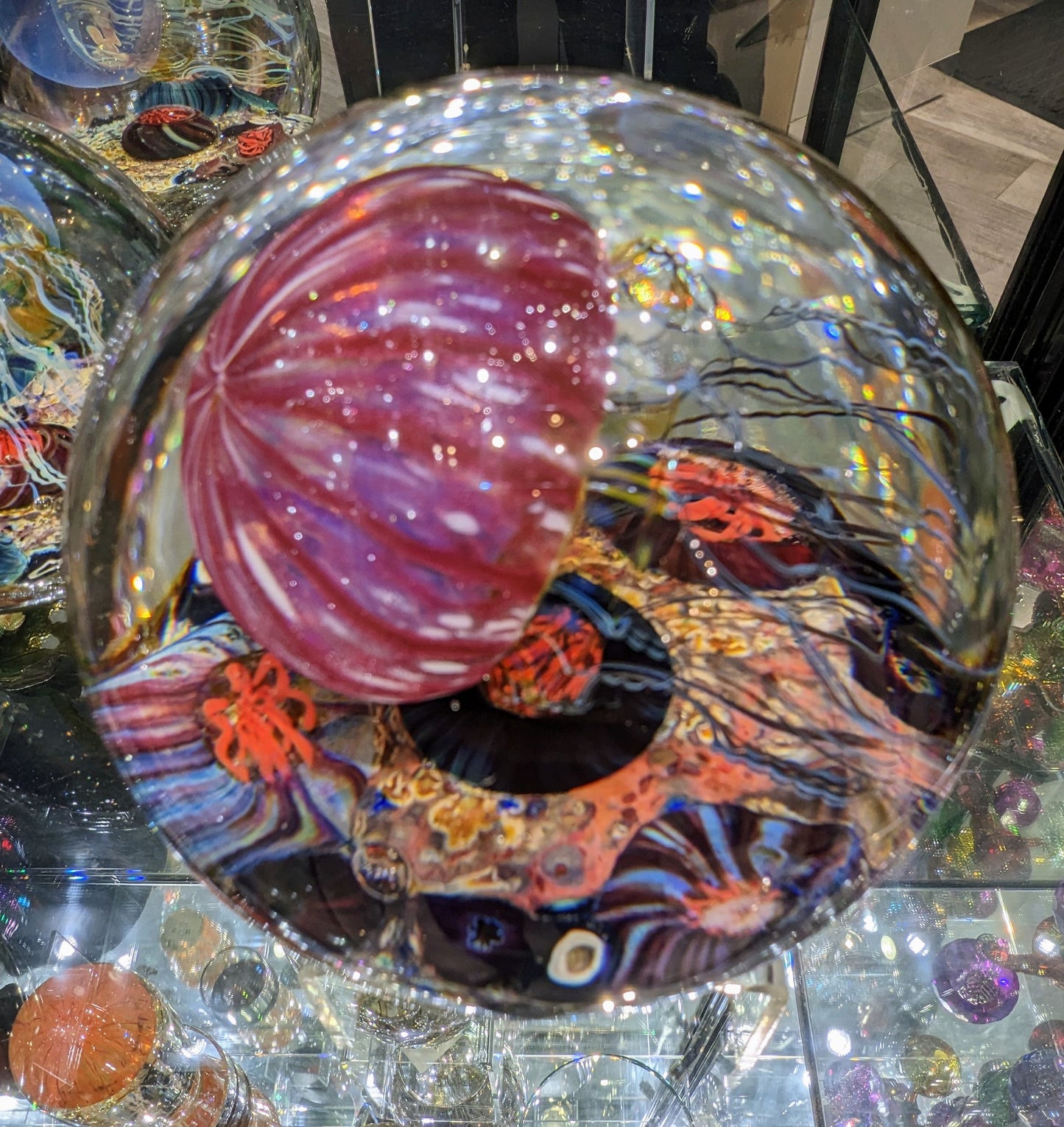 A handcrafted Satava art glass jellyfish sculpture with a gold and ruby colored body