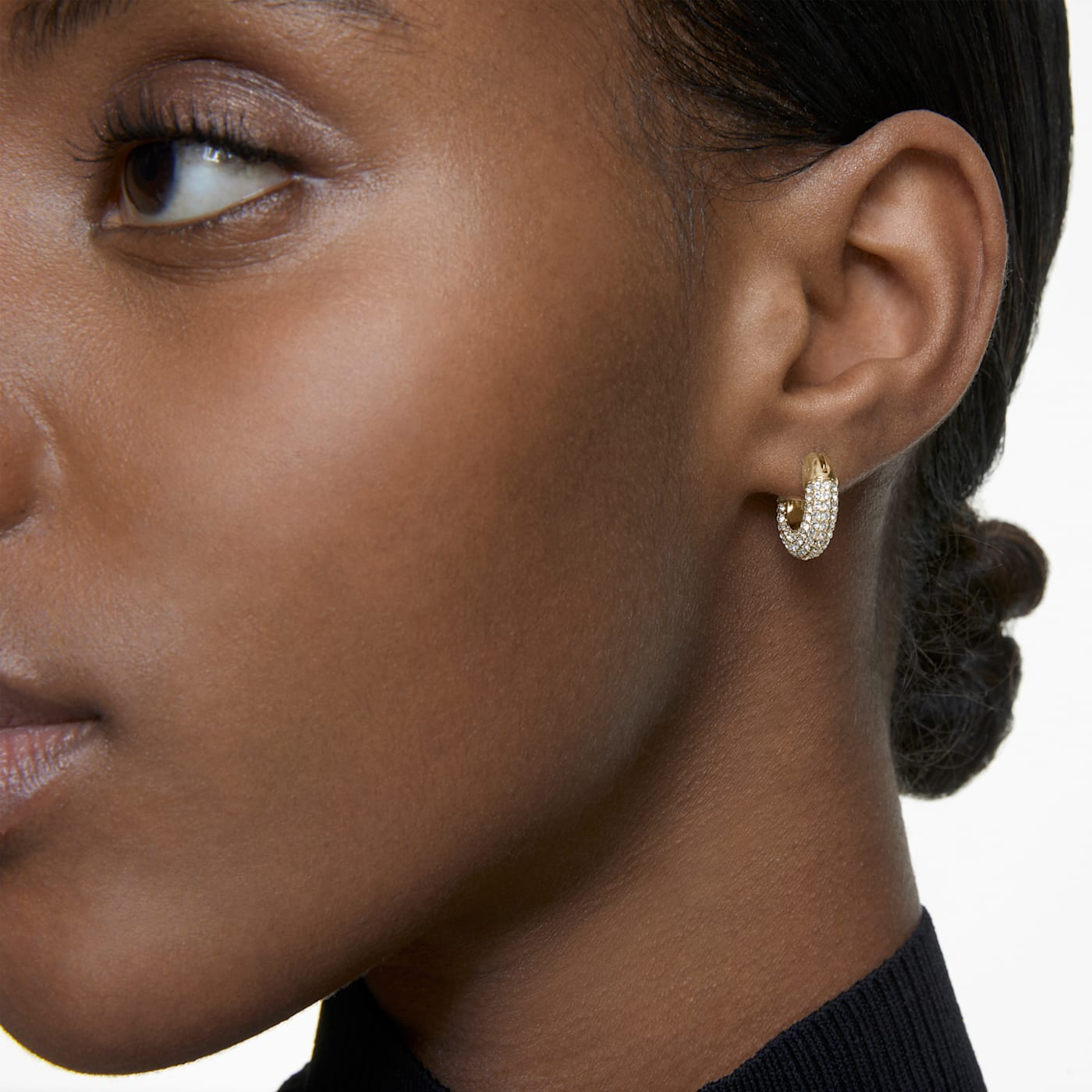 A model is wearing pair of gold-tone plated hoop earrings with white Swarovski crystals hoop.
