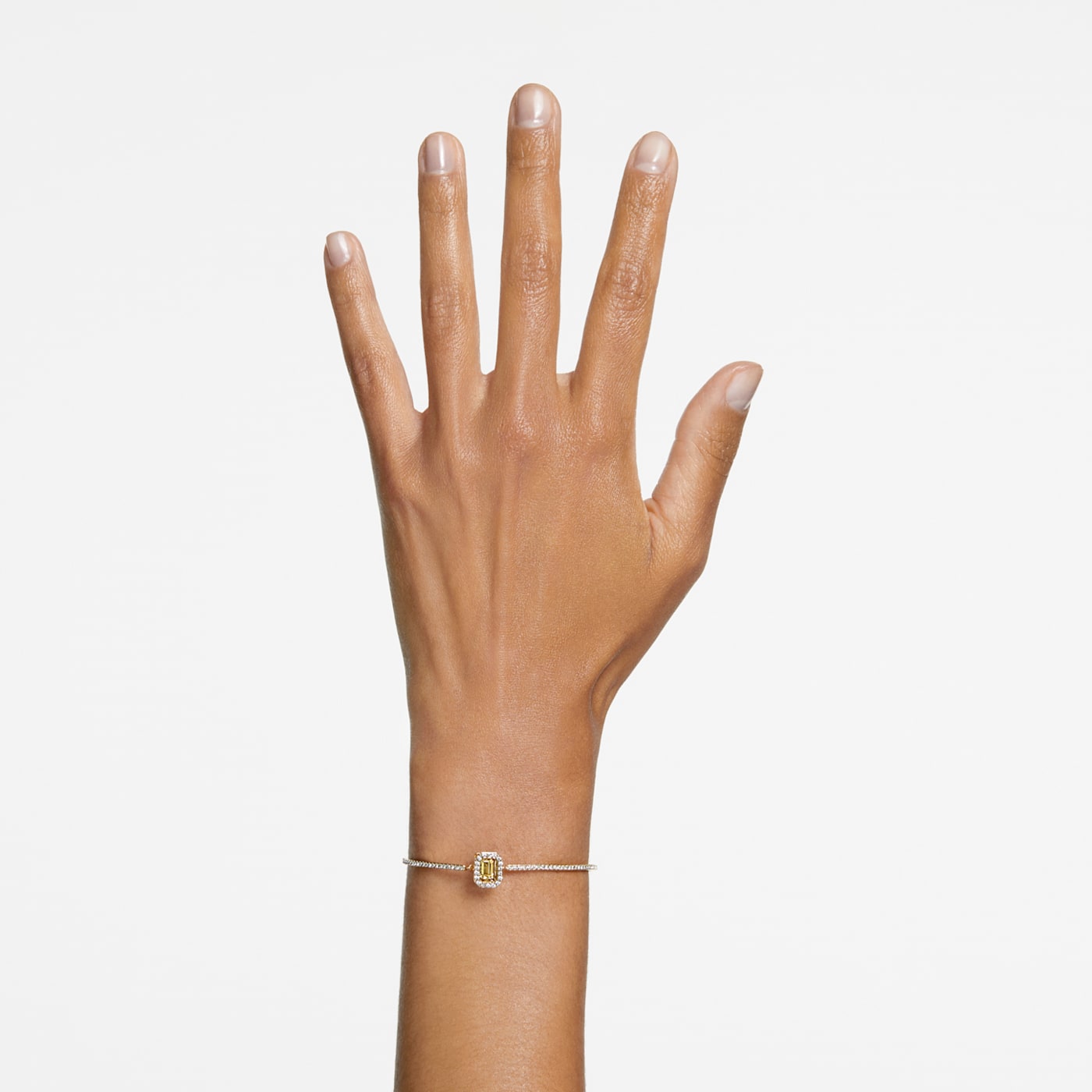 A hand wearing a yellow octagon-cut stone bangle with gold-tone plating.