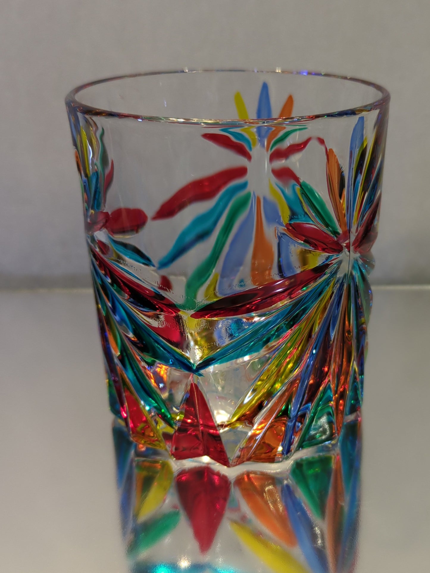 A multicolored, patterned glass whiskey glass.