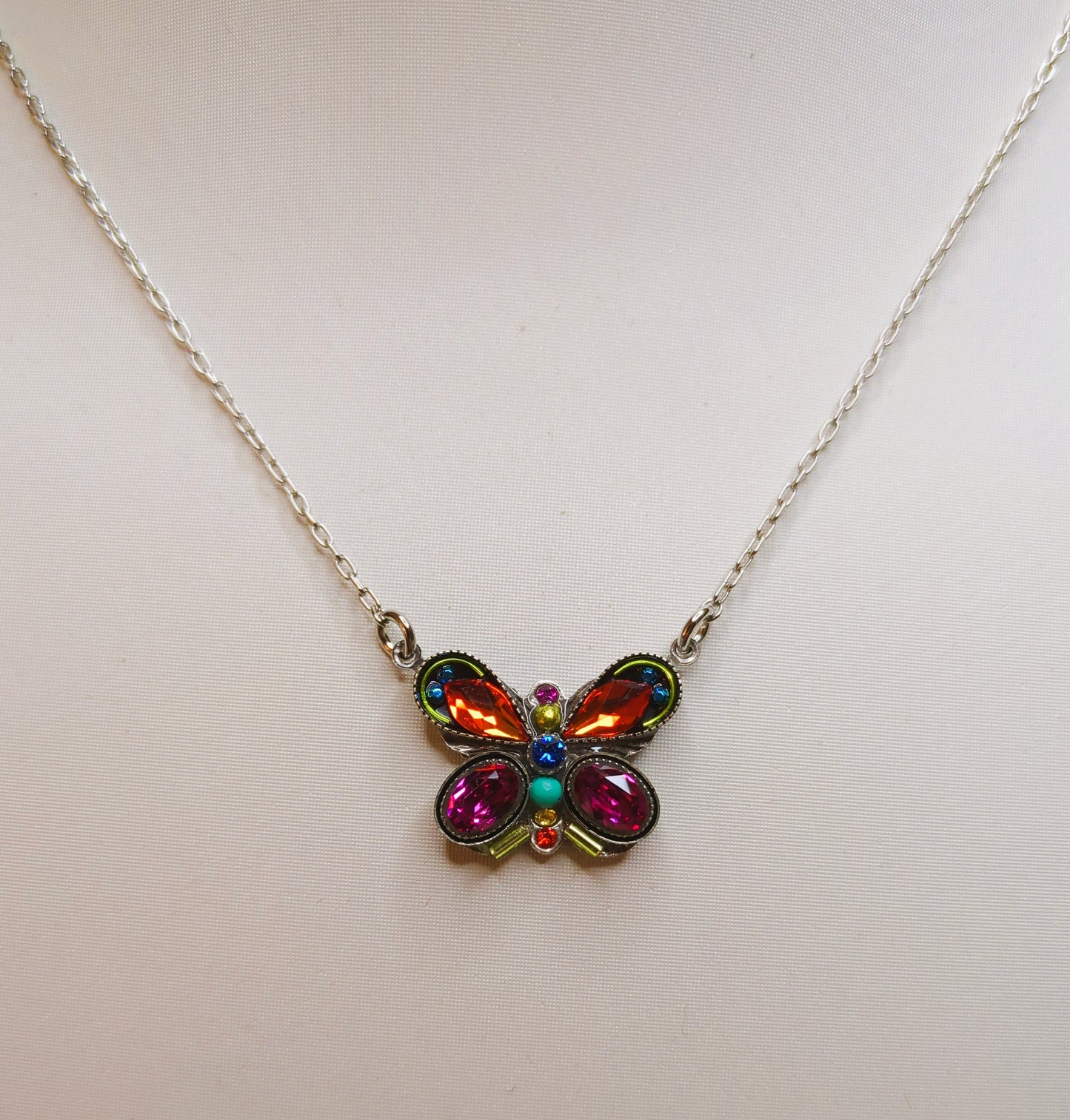 A colorful butterfly-shaped necklace with multicolored crystals and an antiqued steel chain.
