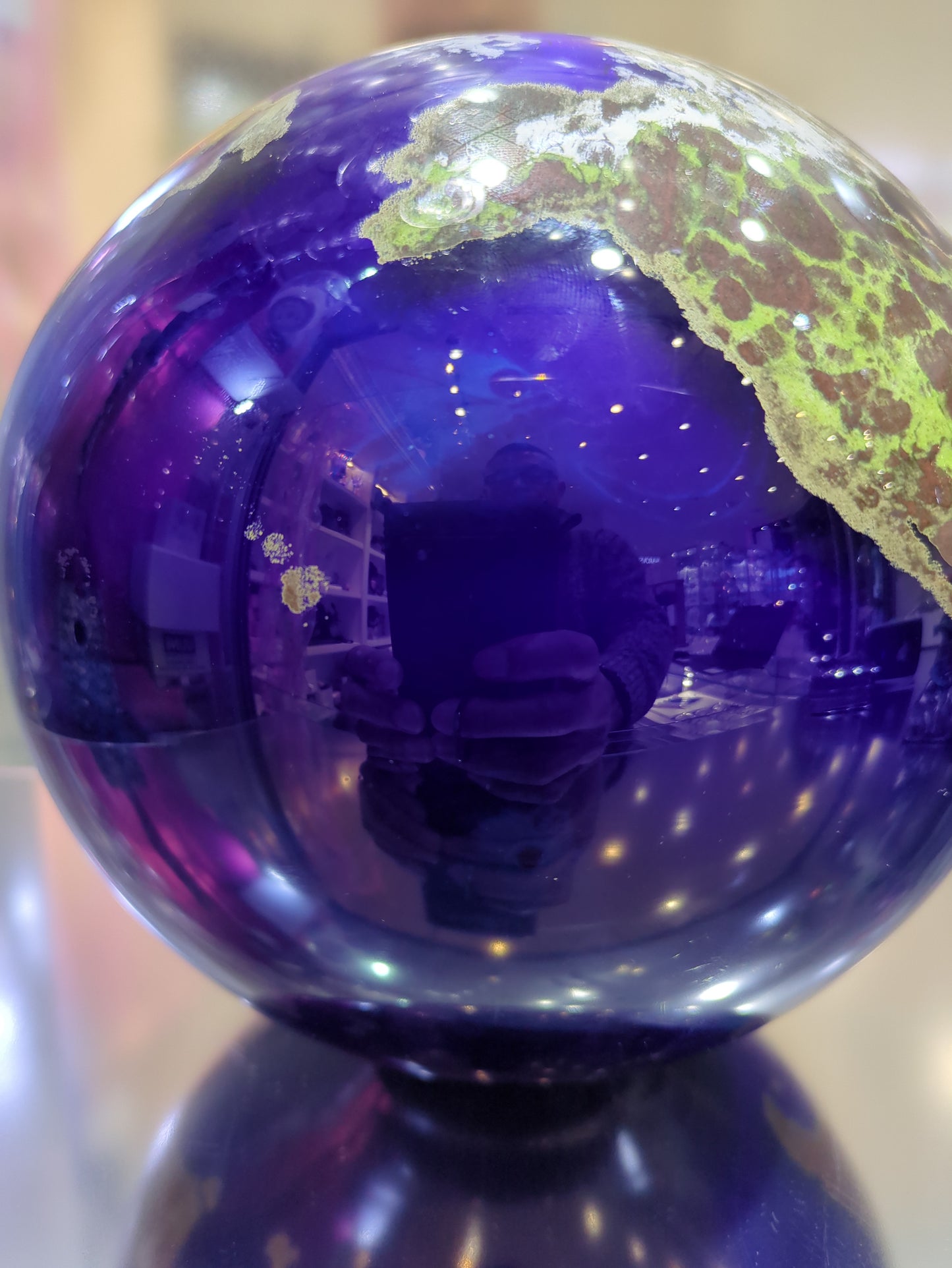 Close-up of a purple glass orb with a reflective surface