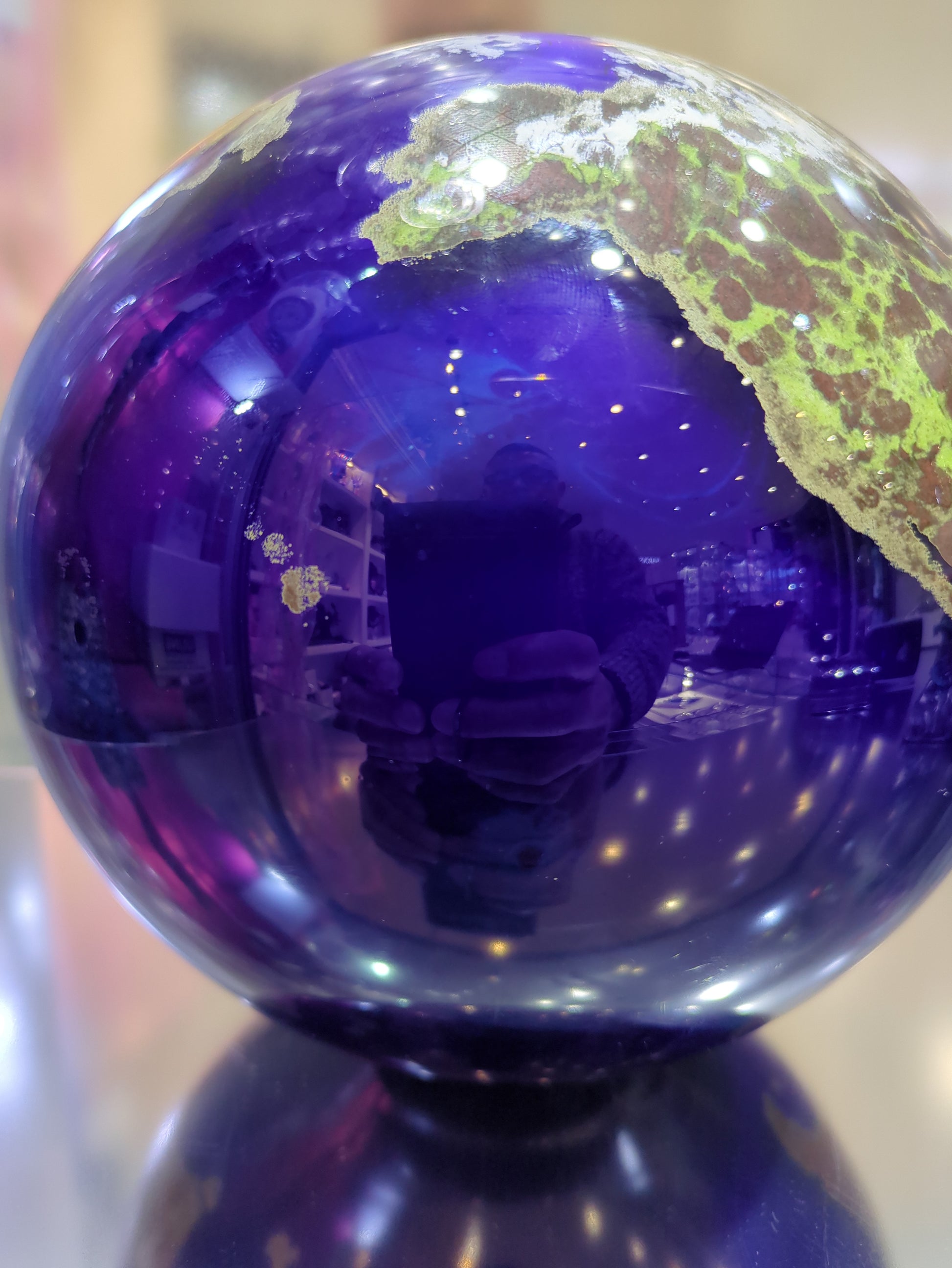 Close-up of a purple glass orb with a reflective surface