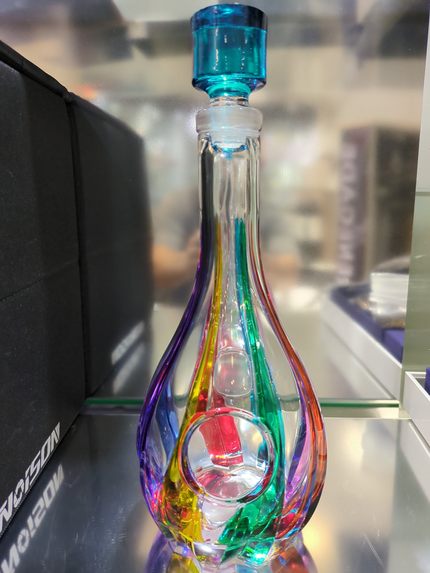 Multicolored glass pipe on a black surface with a blurred background