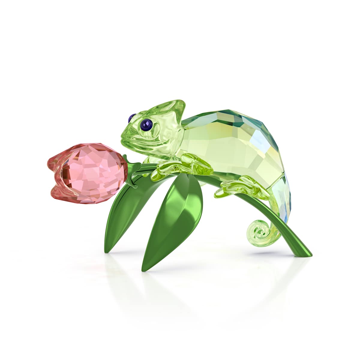 Crystal chameleon figurine on a pink flower with green leaves on a white background