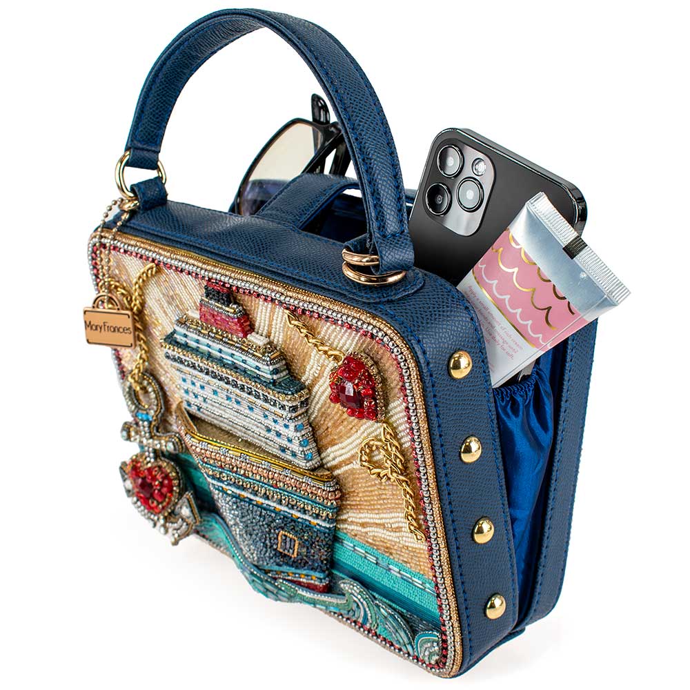 Decorative handbag with intricate designs and a phone inside on a white background