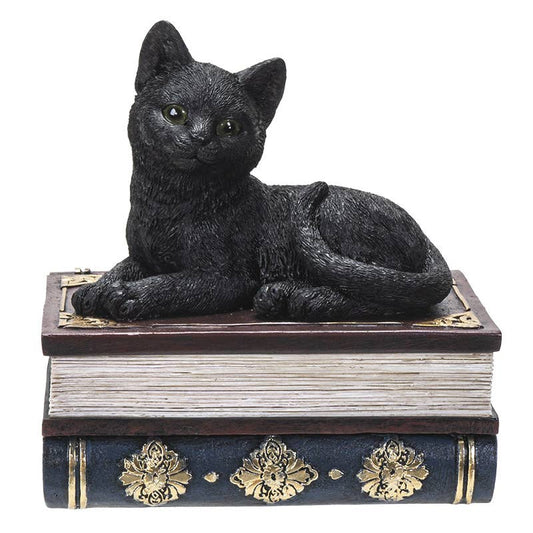 Black cat figurine on top of a decorative book with gold accents