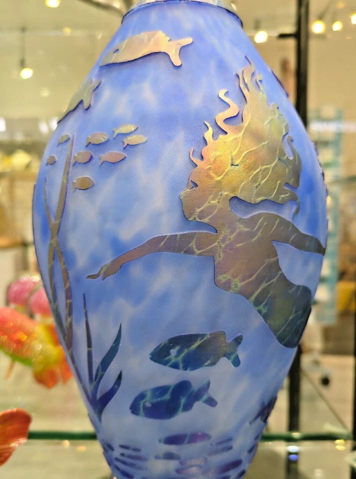 Decorative vase with mermaid and fish design on a blue background