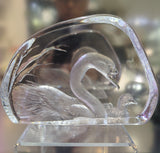 Clear crystal sculpture of a mother and baby swan with intricate detailing on a blurred background