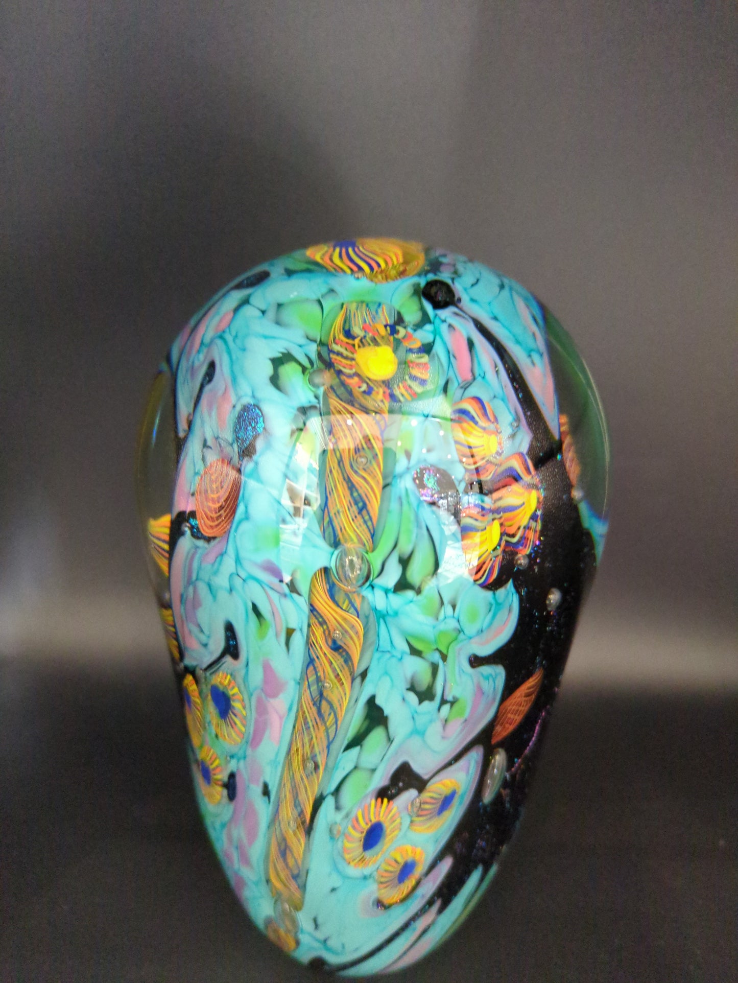 Colorful paperweight with intricate patterns on a dark background