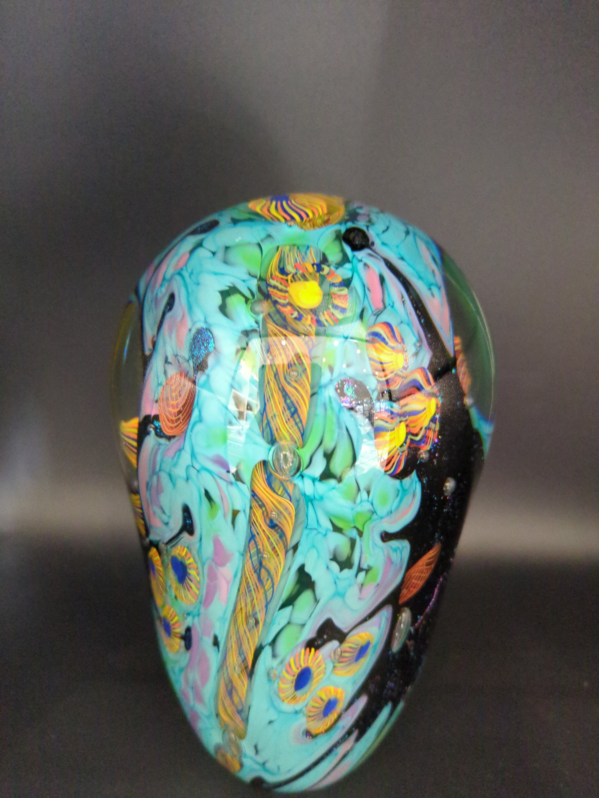 Colorful paperweight with intricate patterns on a dark background