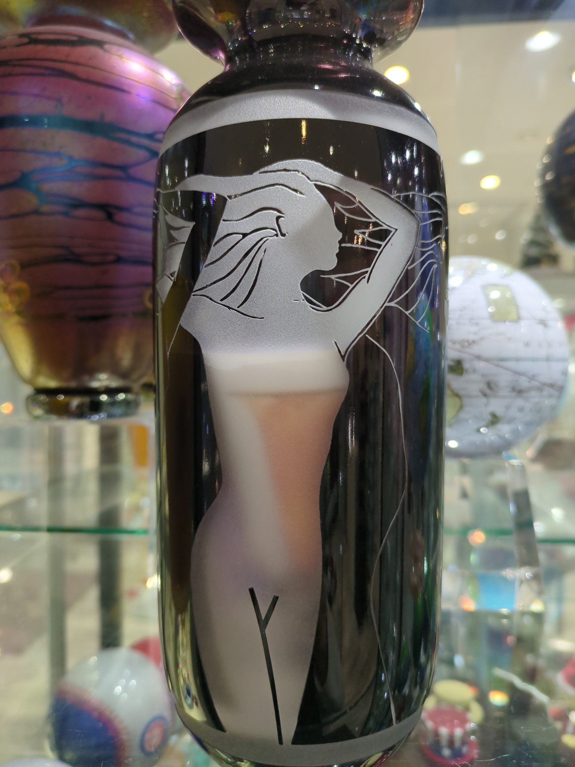 This image features a striking limited edition Correia Black Sand Carved Vase, prominently displaying an artistic rendering of a nude figure. The vase is signed by the artist, emphasizing its collector's value as part of the 129/500 signed limited edition series.