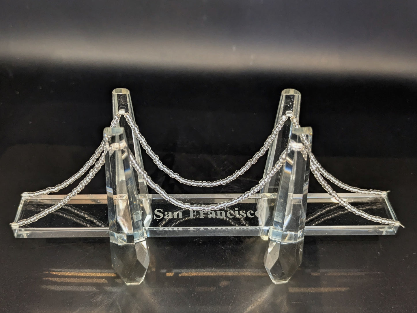Crystal model of a suspension bridge with 'San Francisco' on a dark background