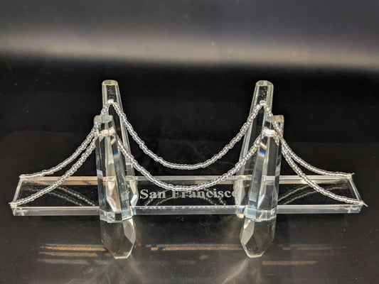 Crystal model of a suspension bridge with 'San Francisco' on a dark background