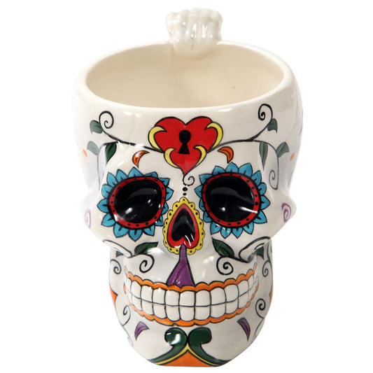 Colorful skull-shaped mug with decorative design on a white background