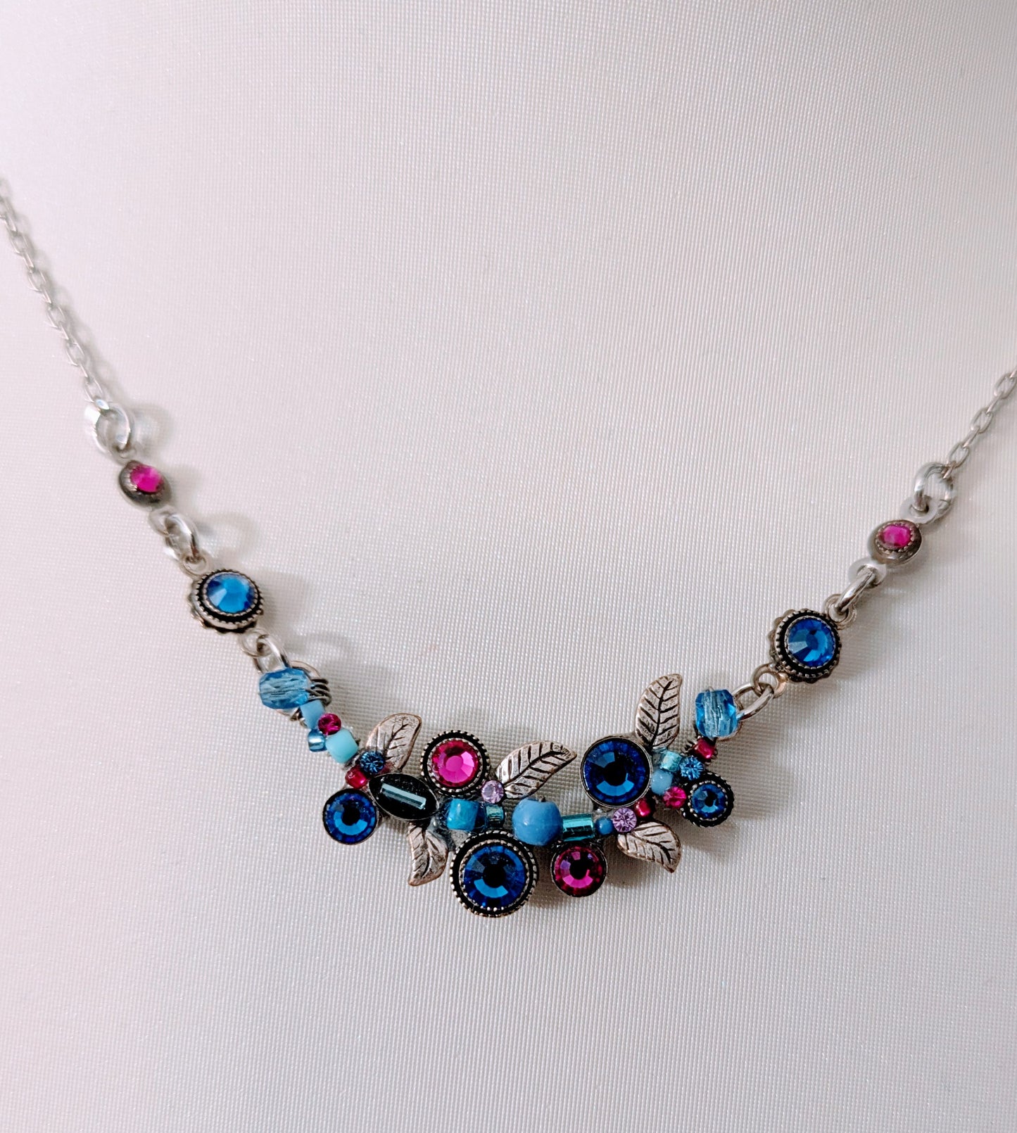 Necklace with colorful beads and silver chain on a white background