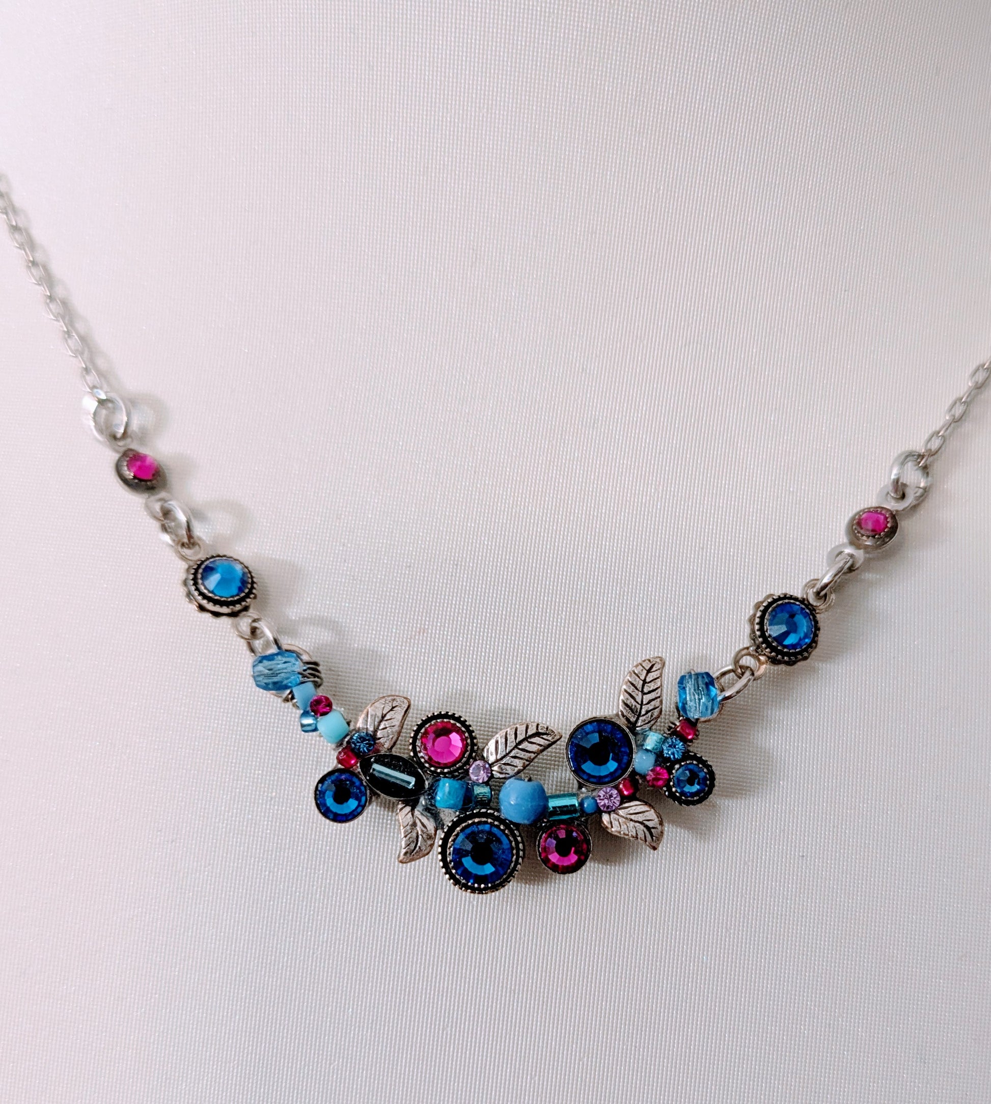 Necklace with colorful beads and silver chain on a white background