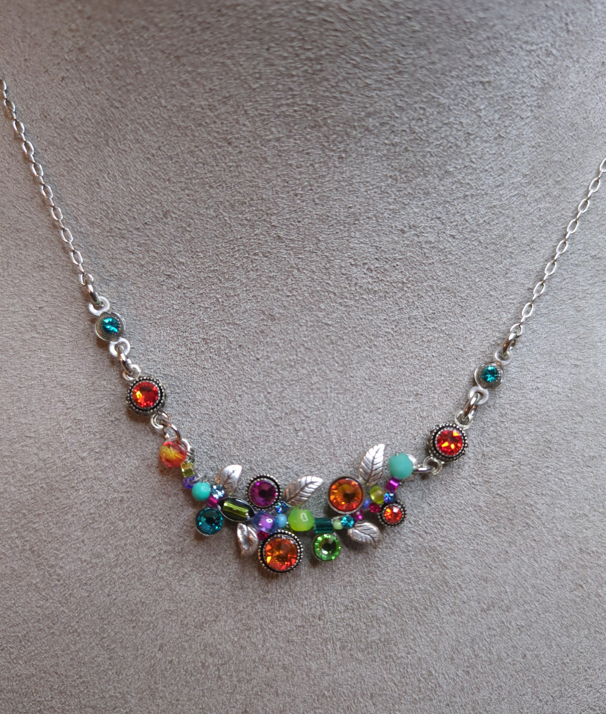 A colorful necklace with a cluster of multicolored crystals