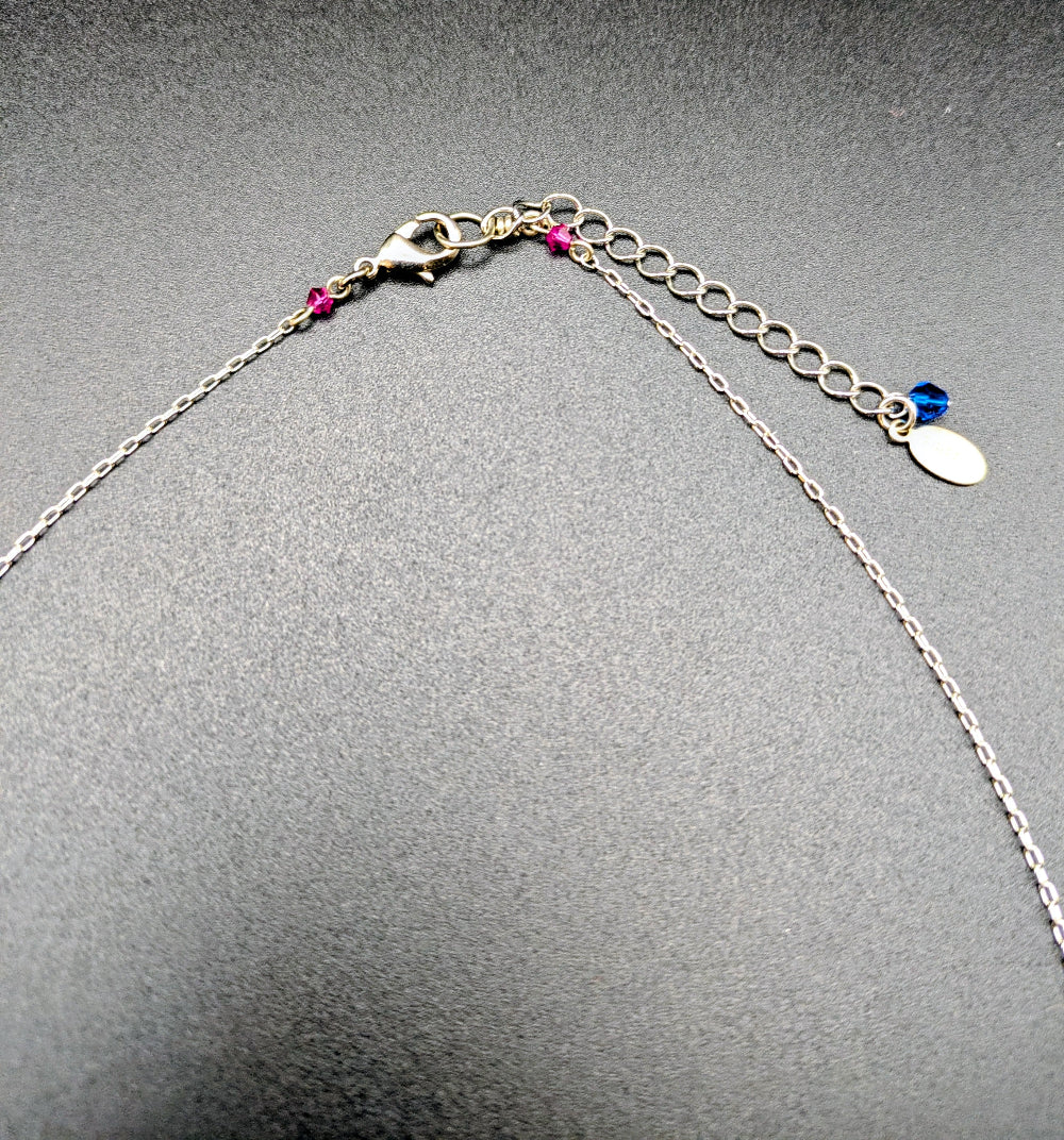 Picture of lobster clasp of pendant on gray background.