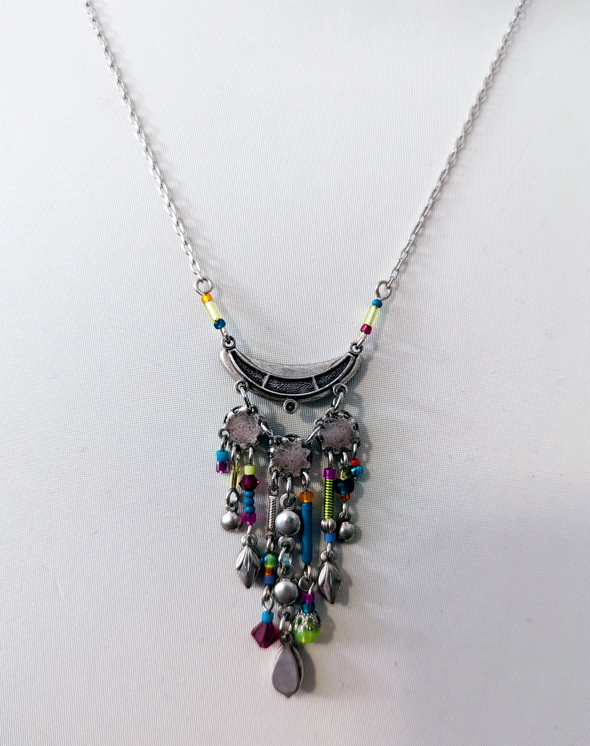 Necklace back view with colorful beads and charms on a white background