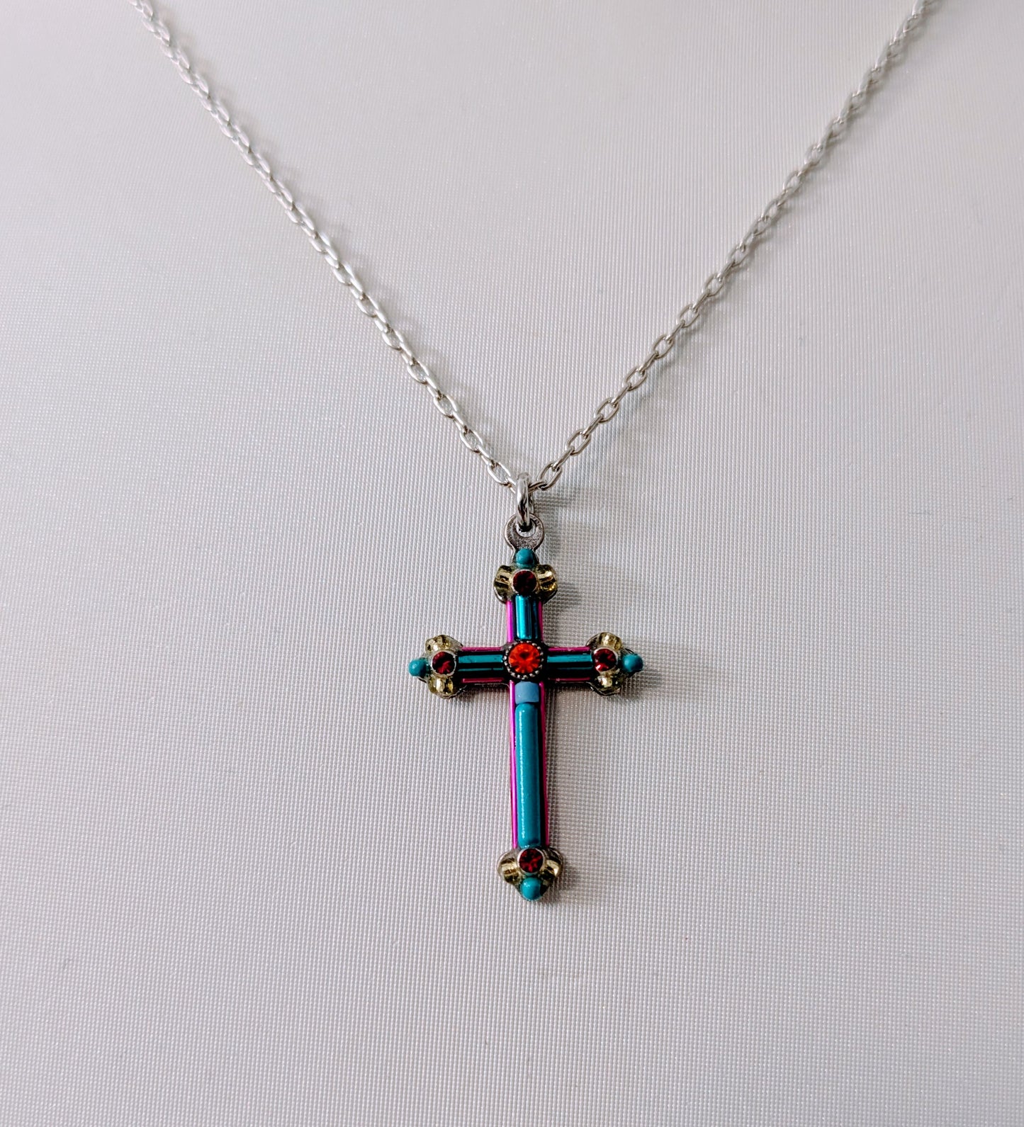 Cross-shaped pendant necklace with colorful design on a white background