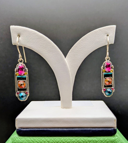 Multicolored gemstone earrings on a white earring stand against a dark background