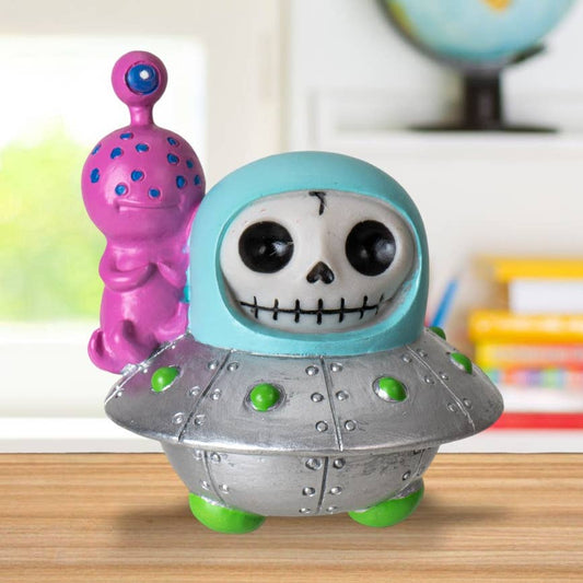 Toy figure of a skeleton in a UFO with a pink and blue spiky object in the background.