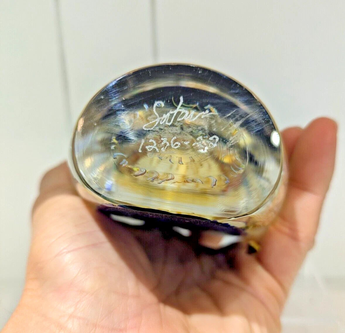 Hand holding a satava glass jelly fish with engraved signed and dated 