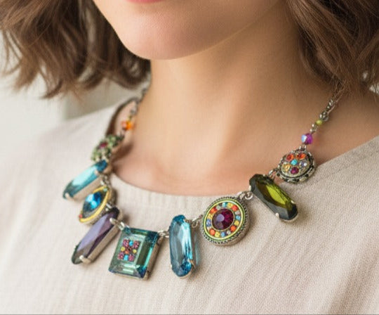Woman wearing a colorful necklace against a plain background