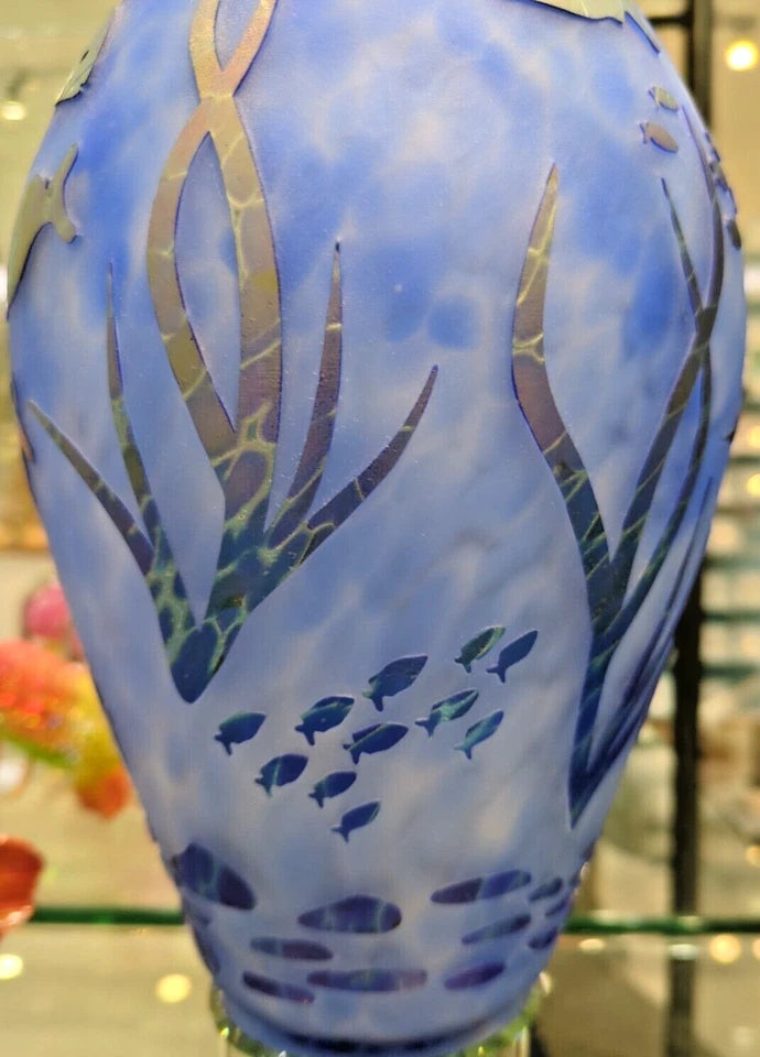 Decorative vase with fish and plant design on a blue background