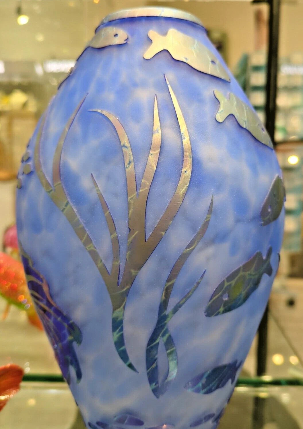 Decorative vase with underwater scene design in a store setting