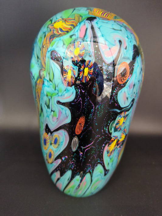 Colorful paperweight with abstract designs on a dark background