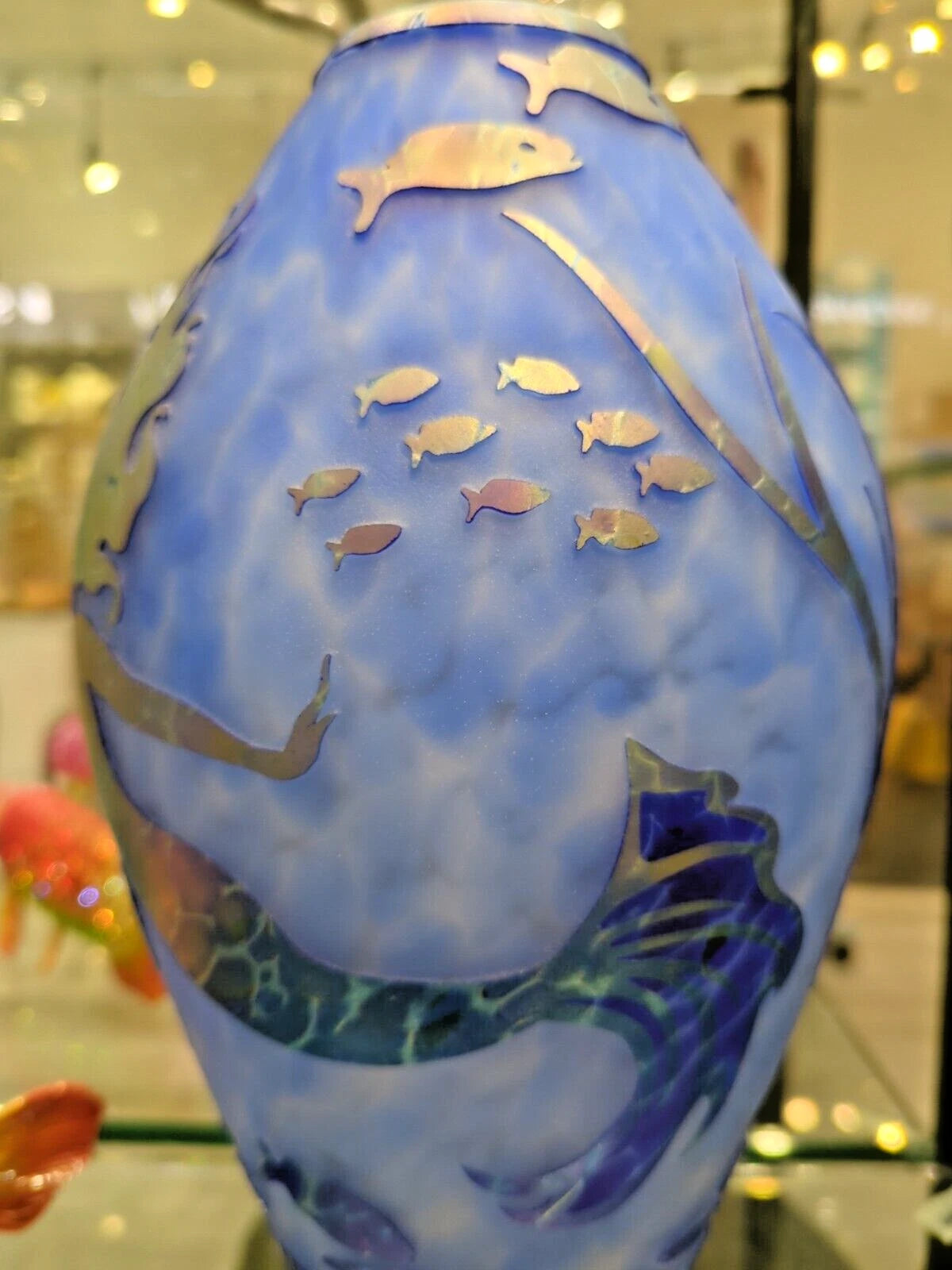 Decorative vase with fish designs on a blue background