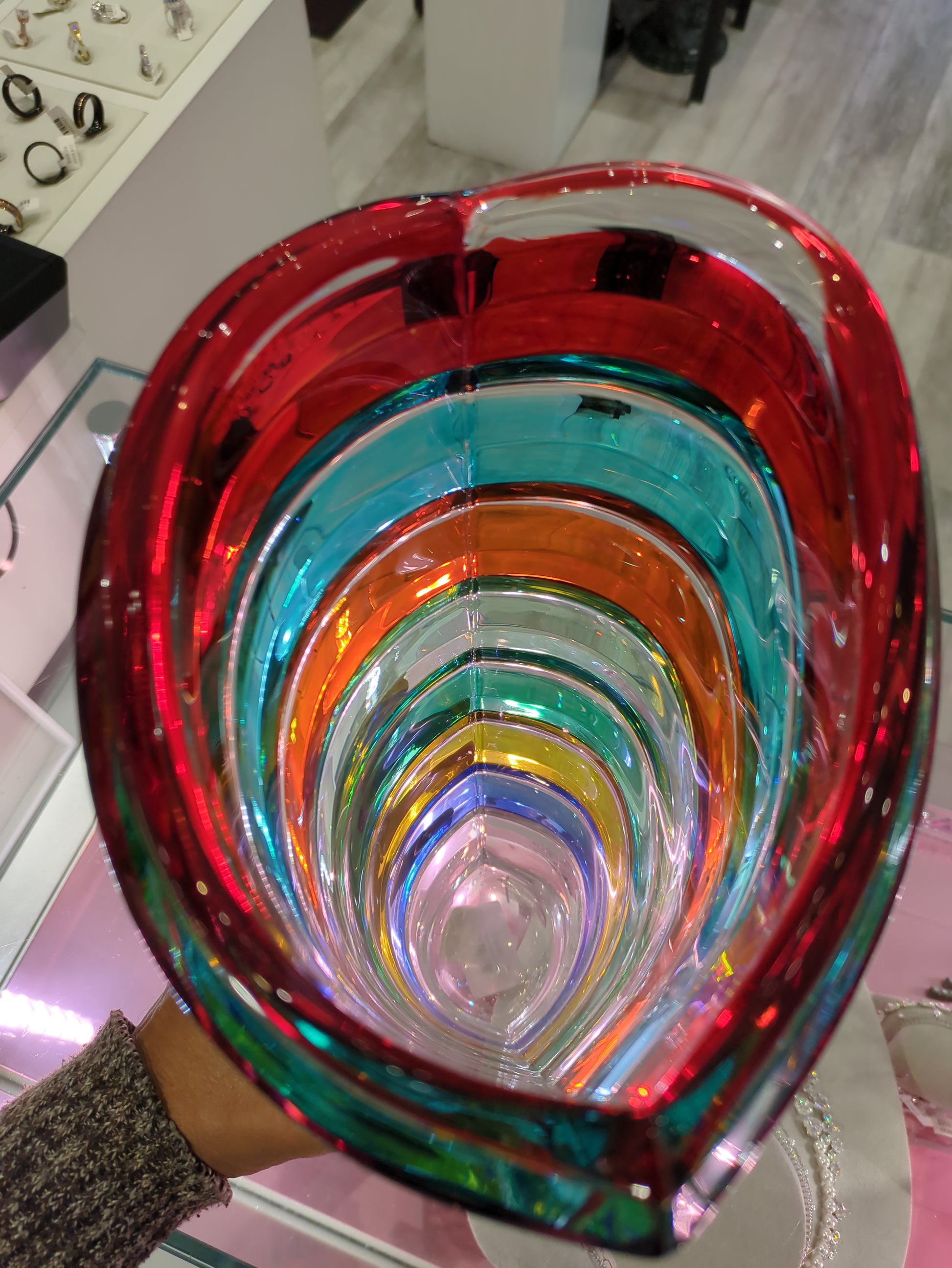 Multicolored glass bowl with concentric swirl pattern on a blurred background