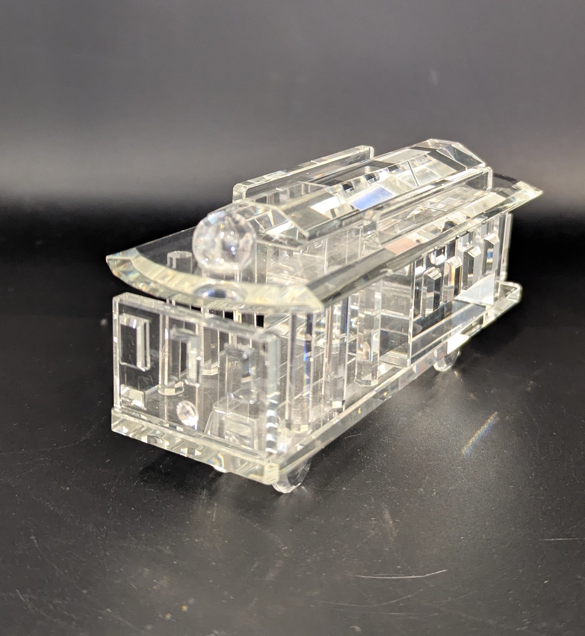 Clear crystal model of a tram on a black background
