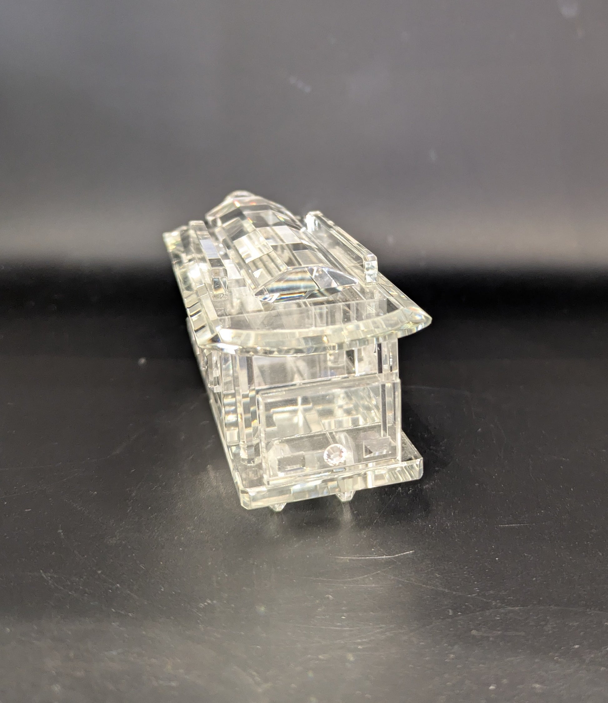 Clear plastic model of a building on a dark surface